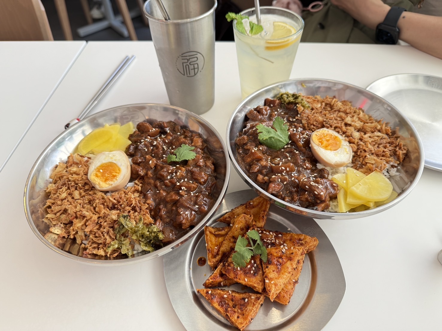 Mesa da Formosa Expo com bowls de aço inox e pratos ao centro, para partilhar